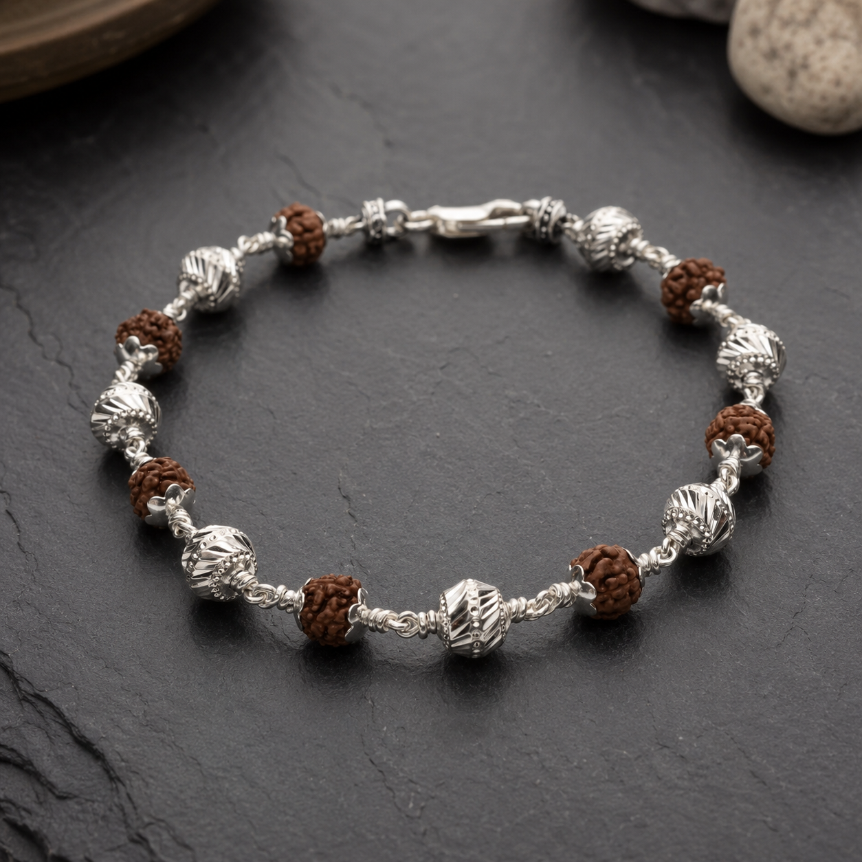 Close-up of patterned CNC silver beads on Rudraksha bracelet