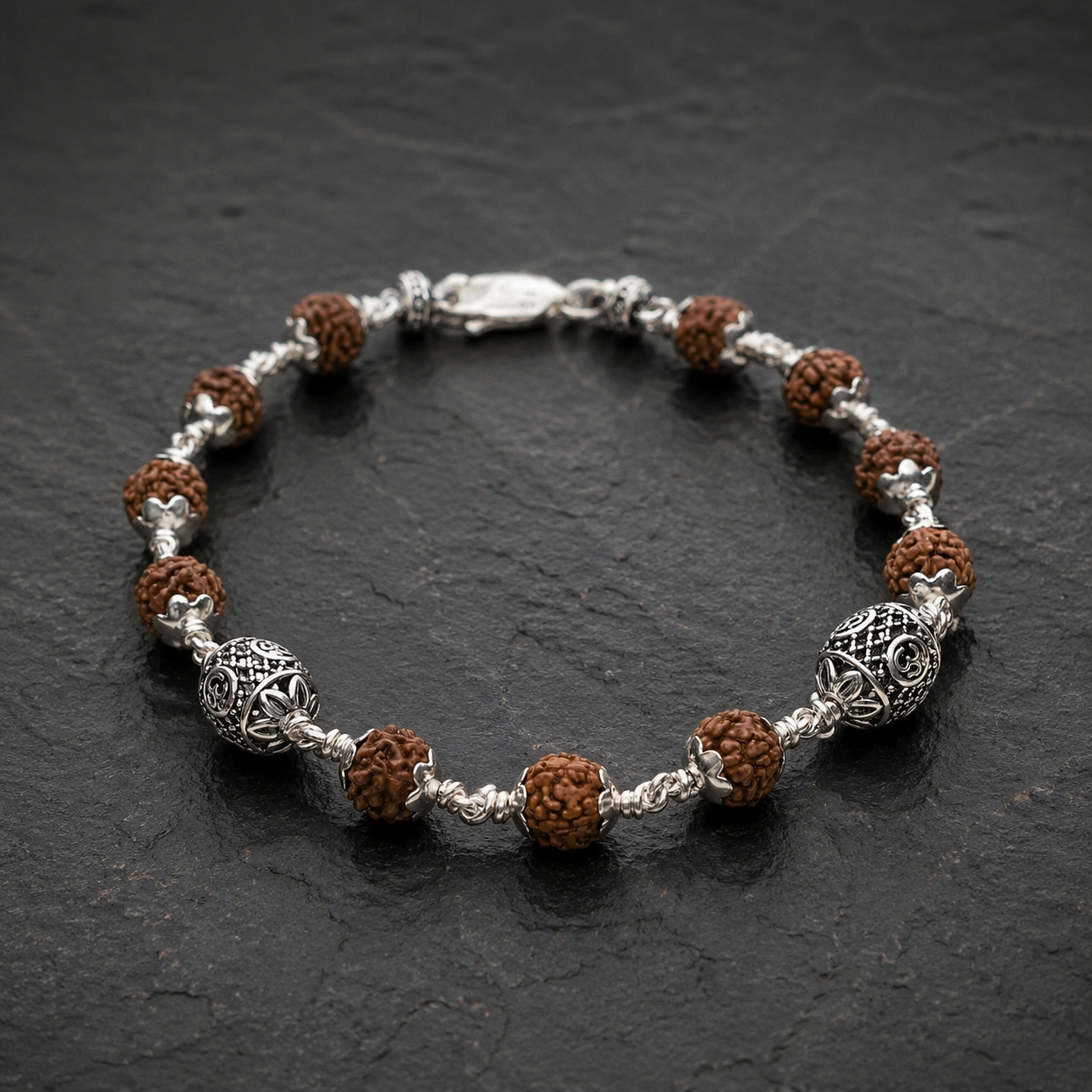 Close-up of 925 silver Oval Om beads on Rudraksha bracelet
