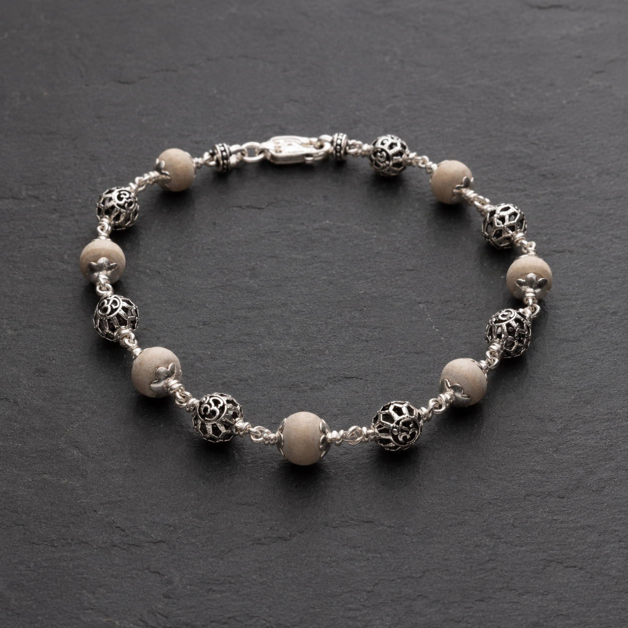 Close-up of 925 silver round Om and Tulsi beads