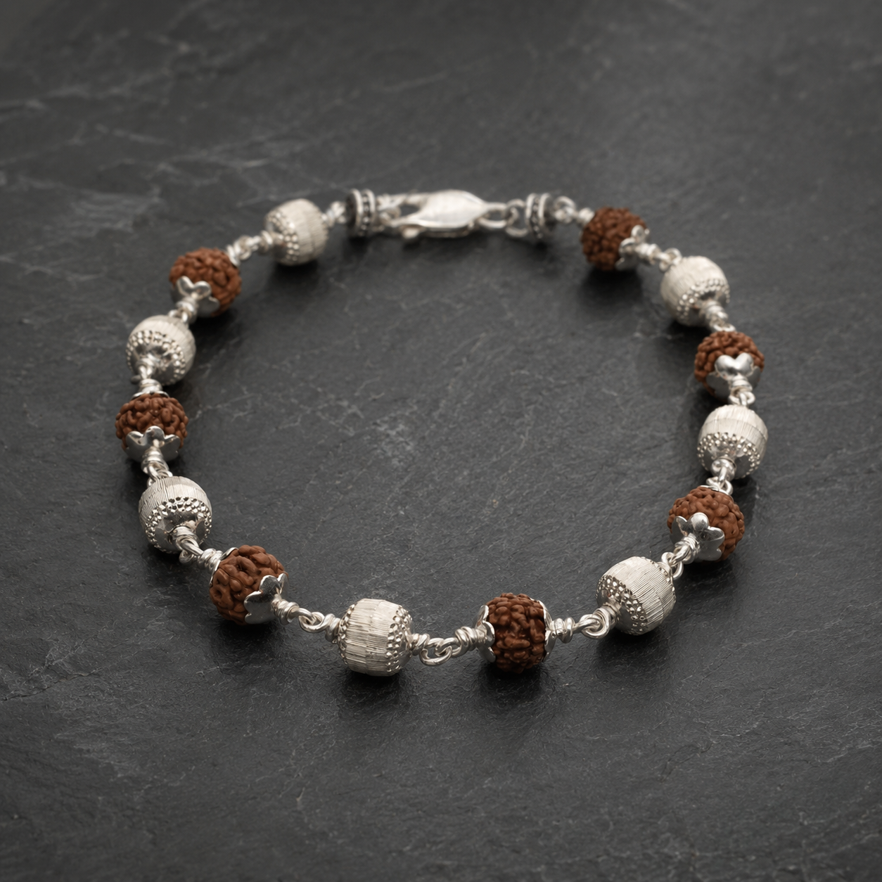 Close-up of cylindrical CNC silver beads on Rudraksha bracelet