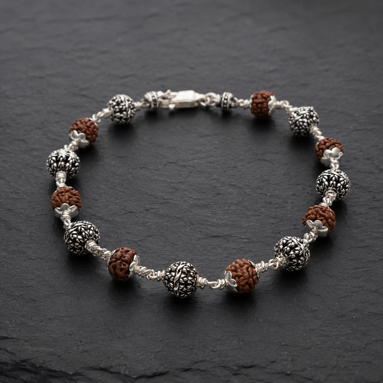 Close-up of silver flower beads on 5 Mukhi Rudraksha bracelet