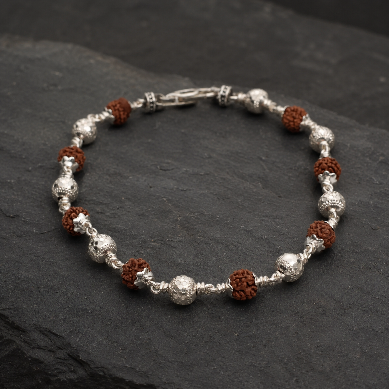 Close-up of textured CNC silver beads on Rudraksha bracelet