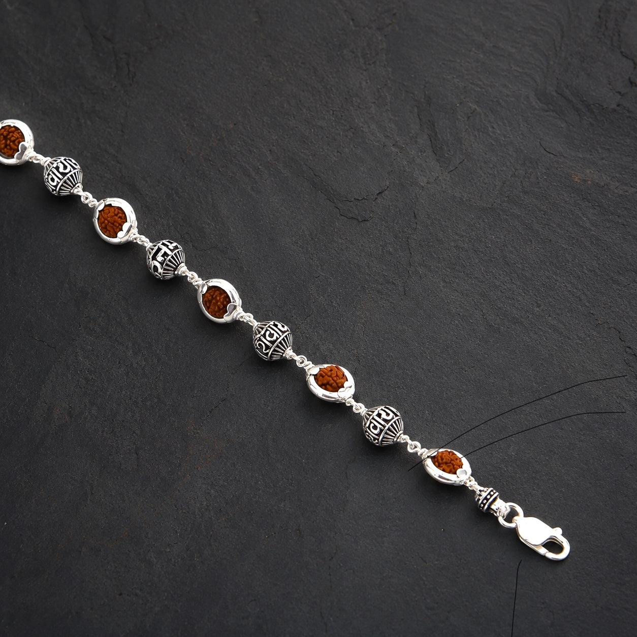 Close-up of Om Namah Shivaya sterling silver beads with Rudraksha